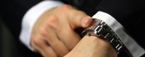 A businessman looking at his watch, deadline/due theme